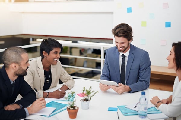 Group of business people sitting at table laughing