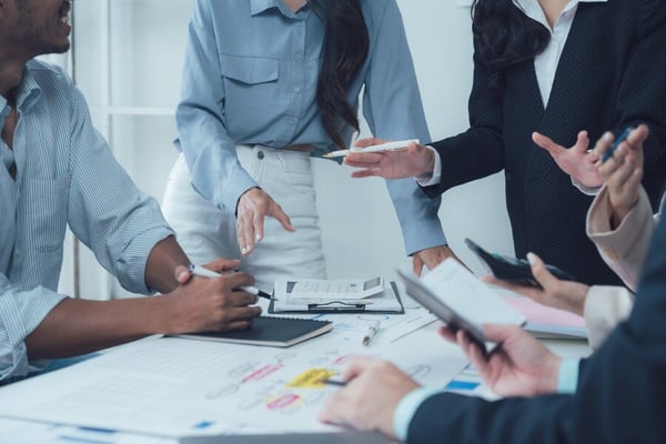 Upper bodies of business people around a table